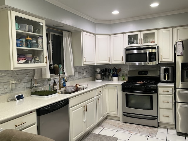 kitchen featuring tasteful backsplash, sink, ornamental molding, and stainless steel appliances