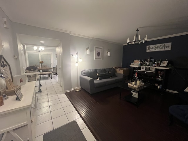 living room featuring an inviting chandelier, light tile patterned floors, and crown molding