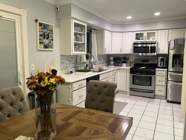 kitchen featuring sink, crown molding, white cabinetry, stainless steel appliances, and decorative backsplash