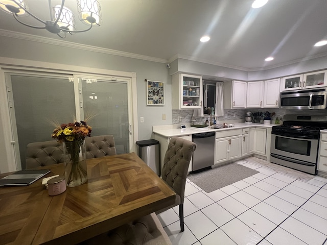 kitchen with sink, decorative light fixtures, appliances with stainless steel finishes, decorative backsplash, and white cabinets