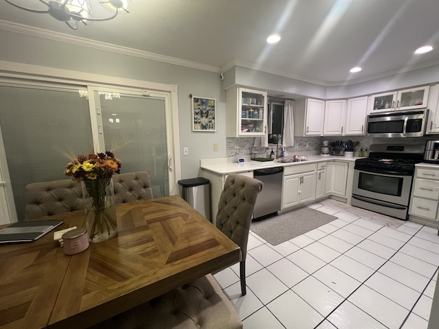 kitchen featuring sink, white cabinets, backsplash, stainless steel appliances, and crown molding