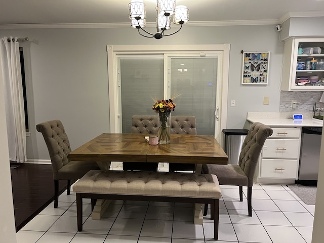 dining room with light tile patterned flooring, ornamental molding, and a notable chandelier