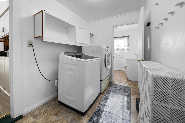 clothes washing area featuring ornamental molding and washer and dryer