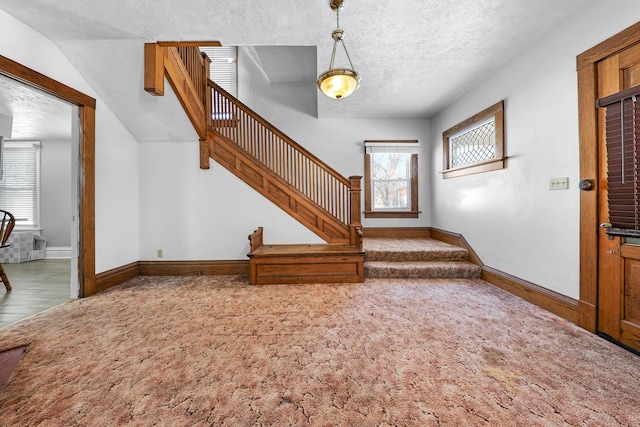 foyer featuring carpet floors and a textured ceiling