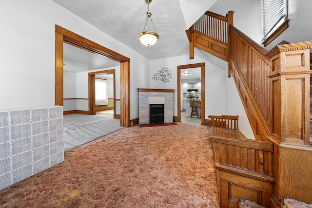 unfurnished living room featuring light colored carpet, lofted ceiling, and a textured ceiling