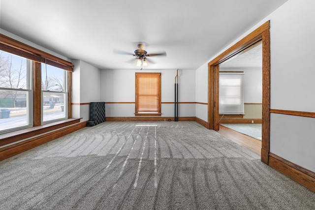 spare room featuring light carpet, a wealth of natural light, and ceiling fan