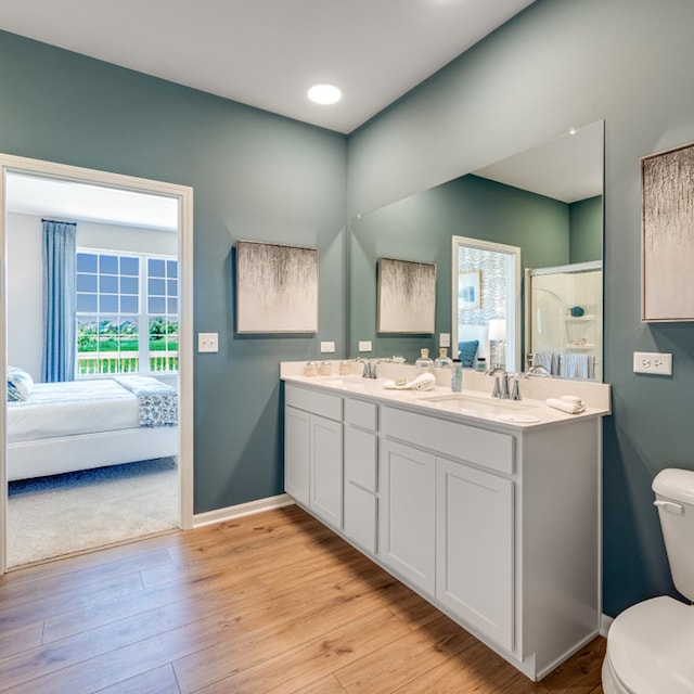 bathroom featuring hardwood / wood-style floors, vanity, toilet, and walk in shower