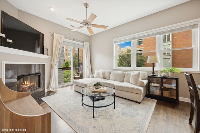 living room featuring wood-type flooring and ceiling fan