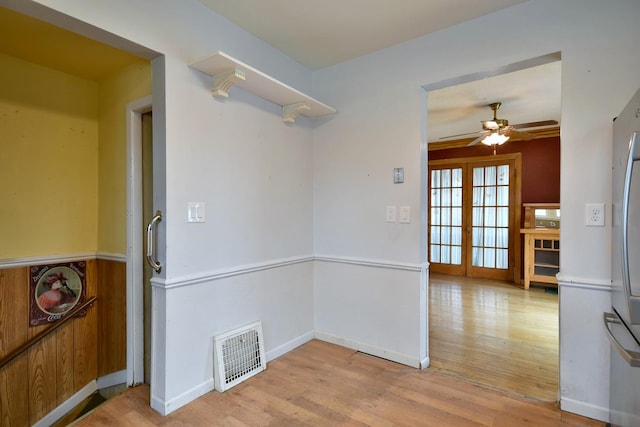 empty room with light hardwood / wood-style floors, french doors, and ceiling fan