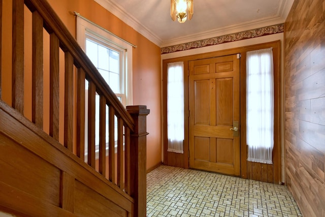 foyer entrance featuring ornamental molding and wood walls