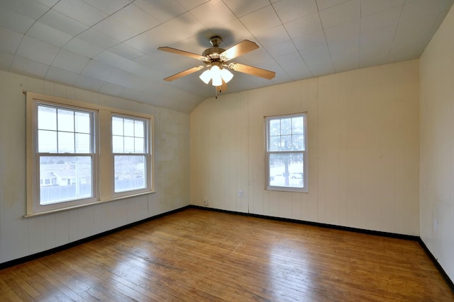 empty room featuring ceiling fan, wood-type flooring, and lofted ceiling