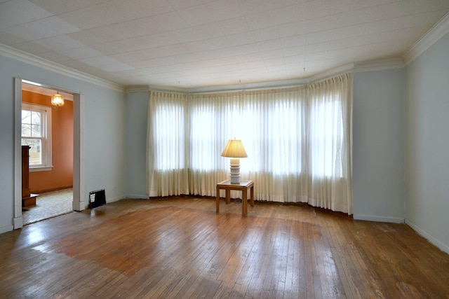 empty room featuring crown molding and hardwood / wood-style flooring