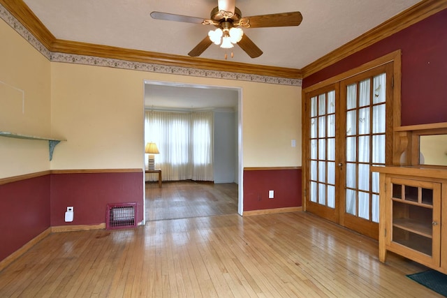 unfurnished room with ornamental molding, light wood-type flooring, and french doors