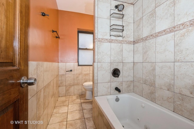 bathroom with tile patterned flooring, toilet, tile walls, and tiled shower / bath