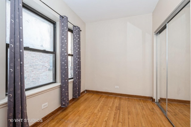 unfurnished bedroom with light wood-type flooring and a closet