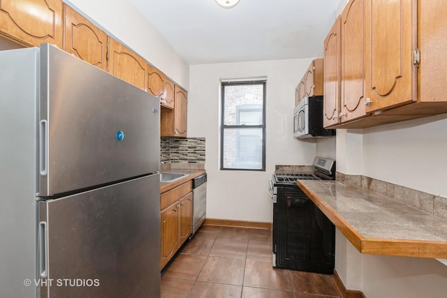 kitchen with sink, tile patterned floors, tile countertops, decorative backsplash, and appliances with stainless steel finishes