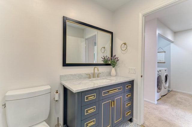 bathroom with independent washer and dryer, vanity, and toilet