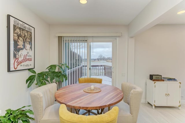 dining area featuring a water view and light hardwood / wood-style flooring