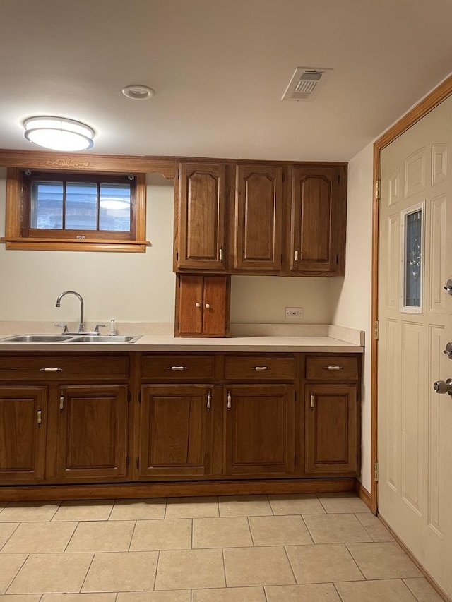 kitchen featuring light tile patterned floors and sink