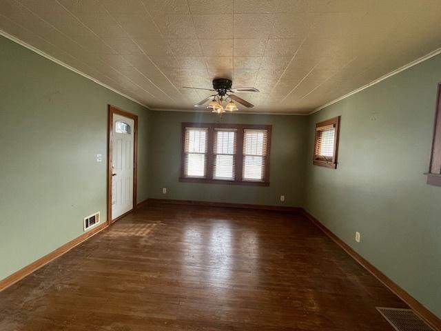 unfurnished room featuring ceiling fan, dark hardwood / wood-style floors, and ornamental molding