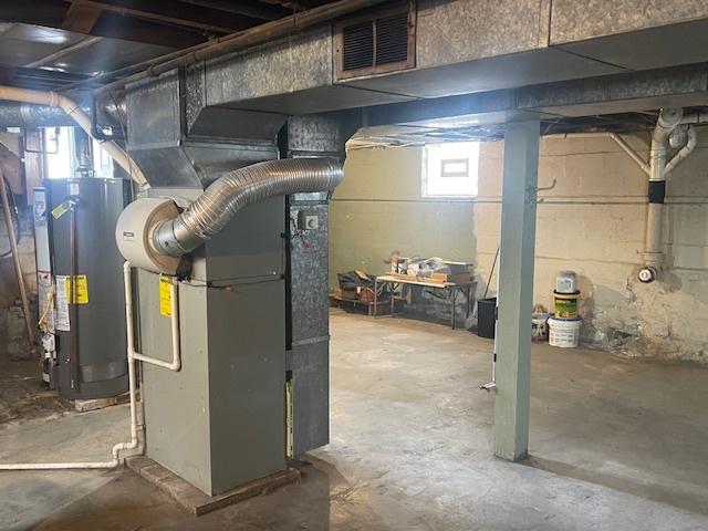 utility room with heating unit and water heater