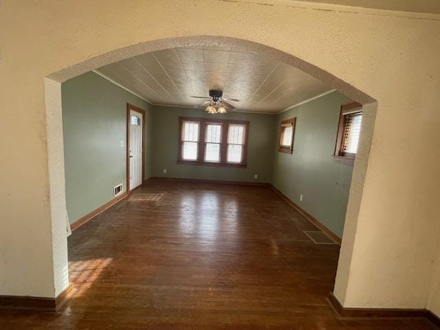 empty room featuring dark hardwood / wood-style floors, ceiling fan, and ornamental molding