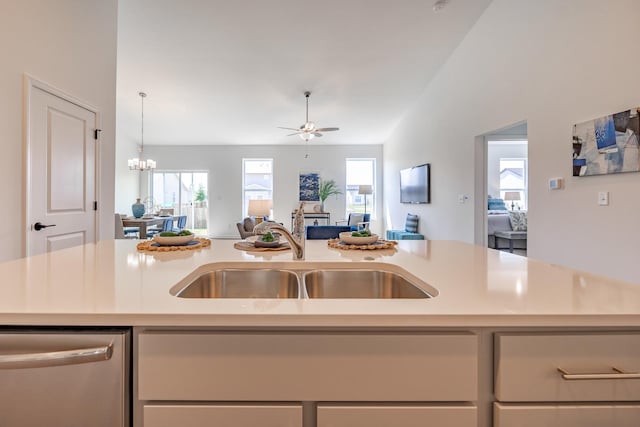 kitchen featuring stainless steel dishwasher, sink, an island with sink, and ceiling fan with notable chandelier