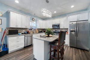 kitchen with pendant lighting, a center island, white cabinets, dark hardwood / wood-style floors, and appliances with stainless steel finishes