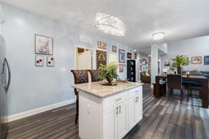 kitchen featuring a kitchen breakfast bar, decorative light fixtures, white cabinets, a center island, and dark hardwood / wood-style floors