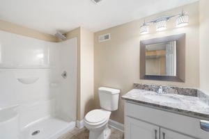 bathroom with a shower, vanity, and toilet