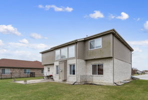 back of house featuring a lawn and a patio