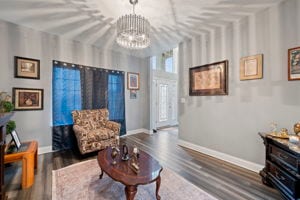 living room with dark wood-type flooring and a notable chandelier