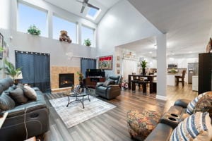 living room with ceiling fan, high vaulted ceiling, and wood-type flooring