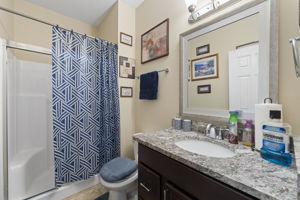 bathroom with a shower with curtain, vanity, and toilet