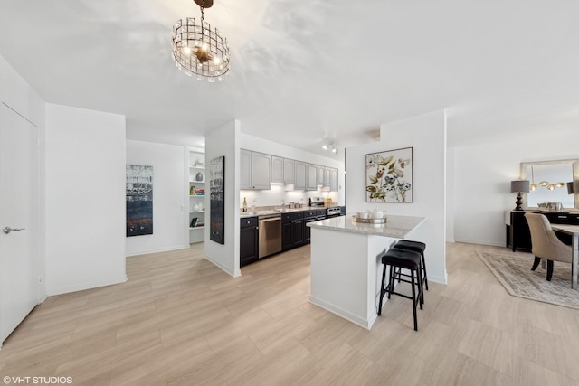 kitchen with gray cabinetry, dishwasher, hanging light fixtures, light stone countertops, and a notable chandelier