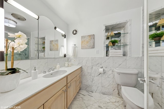 bathroom featuring vanity, toilet, and tile walls