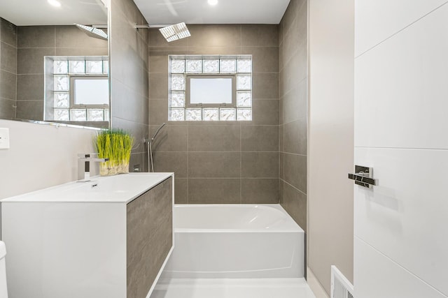 bathroom featuring vanity and tiled shower / bath