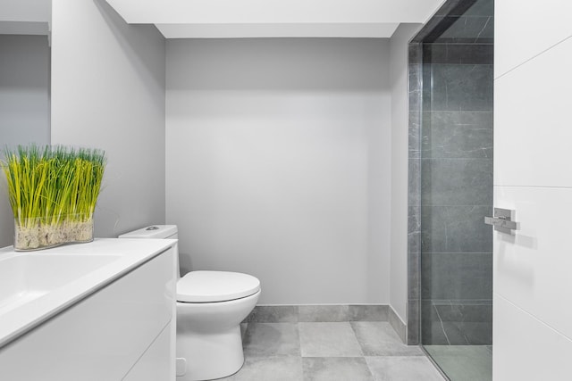 bathroom with tiled shower, vanity, and toilet