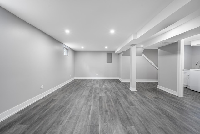 basement with washer / clothes dryer, dark wood-type flooring, and electric panel