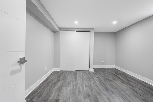 unfurnished bedroom featuring a closet and dark wood-type flooring