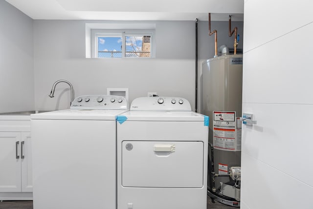 laundry area featuring cabinets, sink, hardwood / wood-style flooring, washer and dryer, and water heater