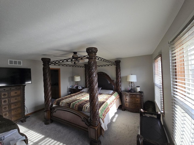 carpeted bedroom featuring ceiling fan and a textured ceiling