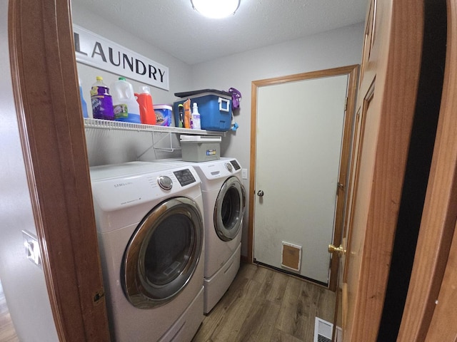 laundry area featuring independent washer and dryer, a textured ceiling, and hardwood / wood-style flooring