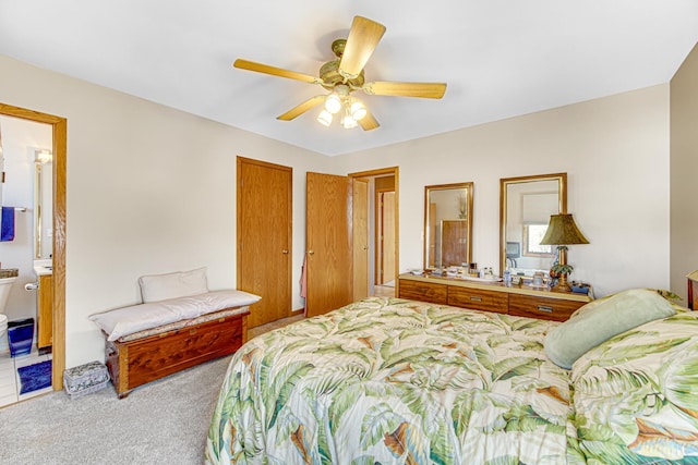 bedroom with ensuite bathroom, ceiling fan, and light colored carpet