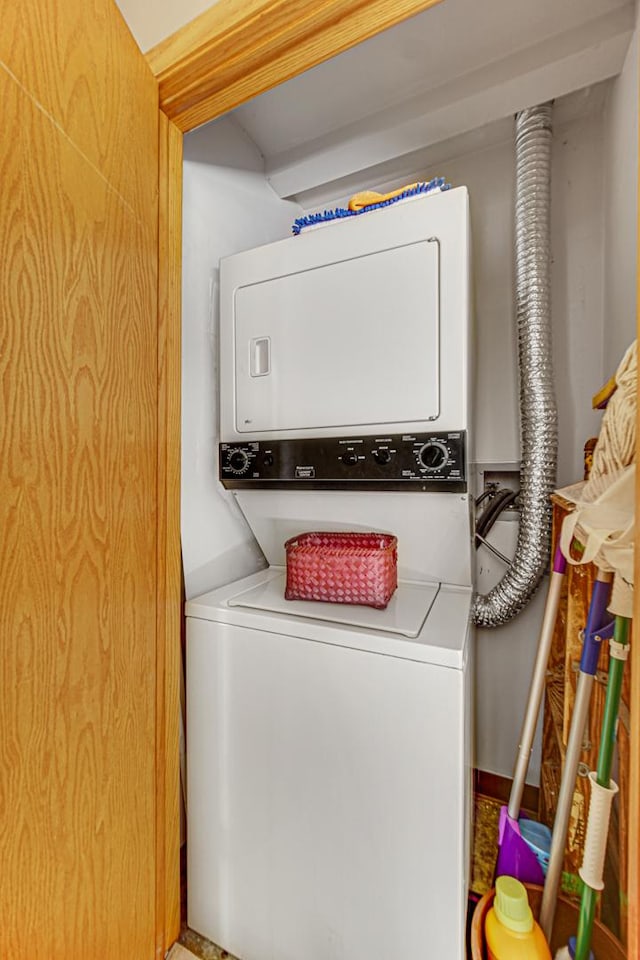 clothes washing area featuring stacked washer and dryer