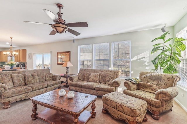 living room with carpet flooring and ceiling fan with notable chandelier