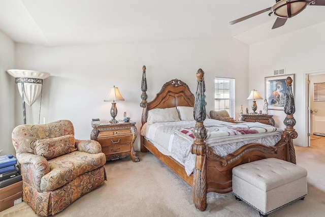 carpeted bedroom featuring ensuite bathroom, vaulted ceiling, and ceiling fan