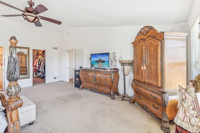 bedroom with lofted ceiling, ceiling fan, a spacious closet, light colored carpet, and a closet