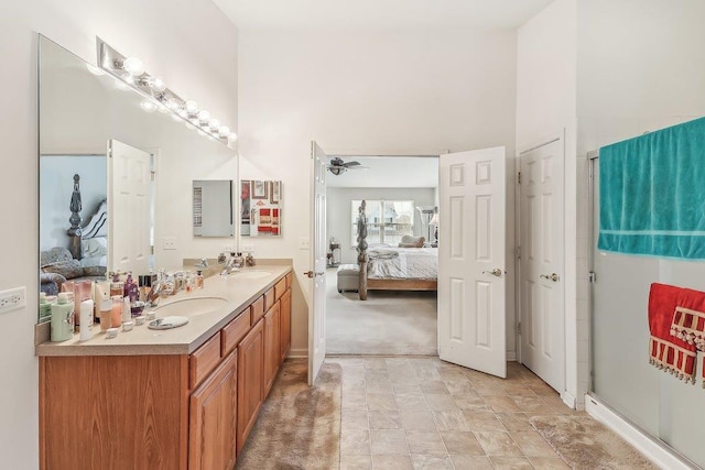 bathroom with ceiling fan, vanity, a shower with shower door, and a high ceiling