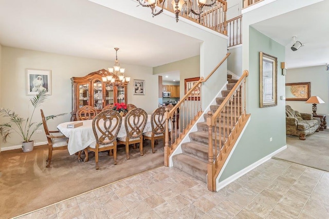 dining space with light carpet and a chandelier